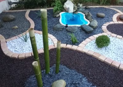 un massif zen avec des bambous, un petit bassin d'eau